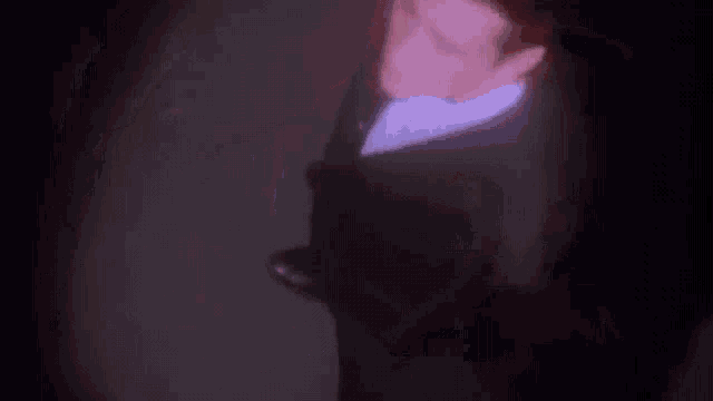a man in a suit and tie is holding a red light saber in his hand .