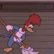 woody woodpecker is holding a mop in his hand and cleaning the floor .