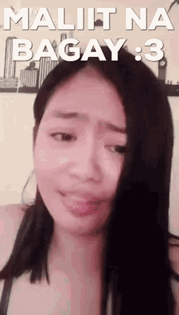 a woman with long black hair is making a funny face with the words maliit na bagay 3 written above her .