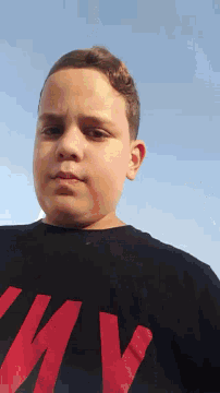 a young man wearing a black shirt with red letters nm