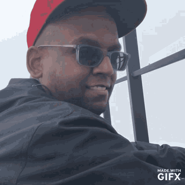 a man wearing sunglasses and a red hat is being made with gifx
