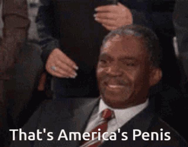 a man in a suit and tie with the words that 's america 's penis above him
