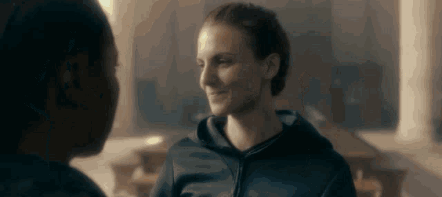 a man and a woman are looking at each other and smiling