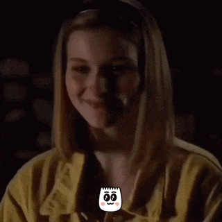 a woman wearing a yellow shirt has a cartoon face on her chest