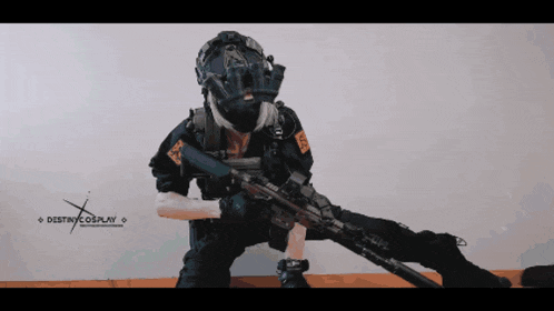 a person in a destroy cosplay costume is holding a rifle