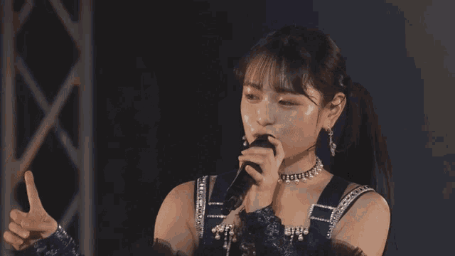 a woman wearing a choker and earrings looks at the camera