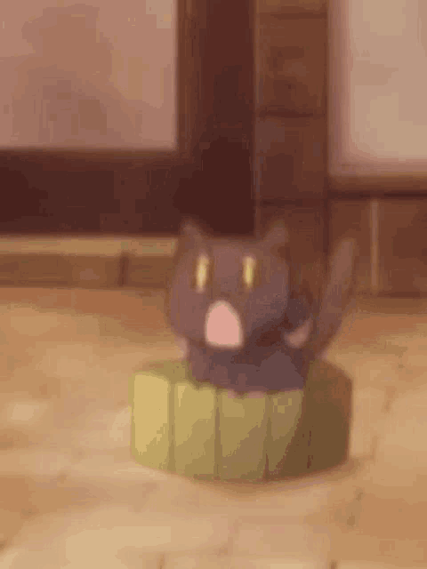 a black cat is sitting on top of a green box .