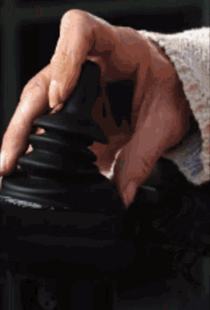 a close up of a person 's hand on a black object