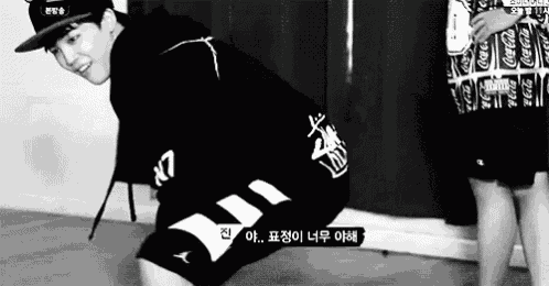 a black and white photo of a boy wearing a hoodie and shorts .