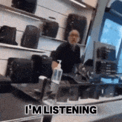 a man sitting at a desk in a store with the words i 'm listening on the bottom