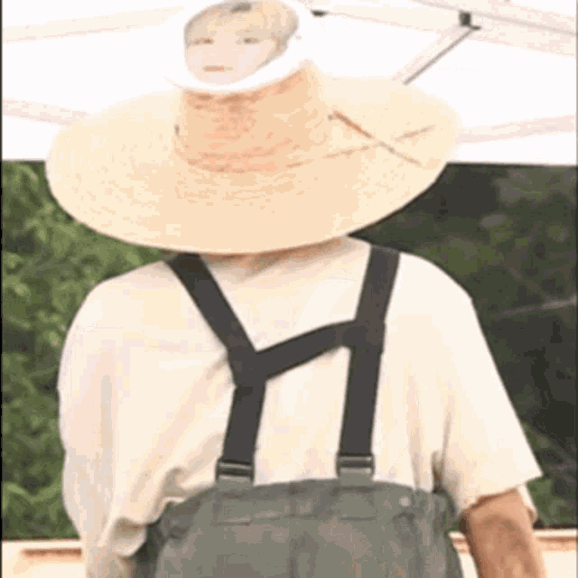 a man wearing a large straw hat with a picture of a man on it .