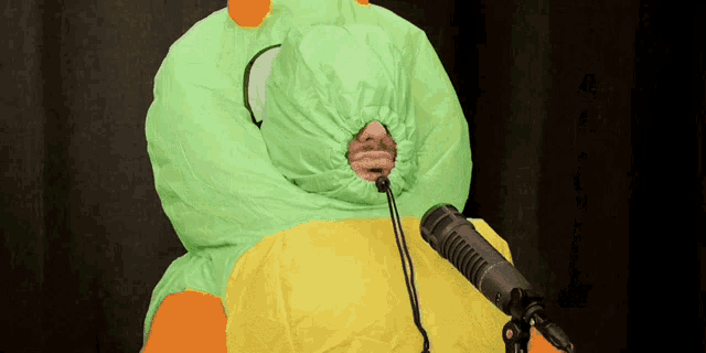 a person in an inflatable frog costume is speaking into a microphone