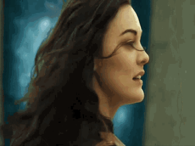 a close up of a woman 's face with long dark hair .