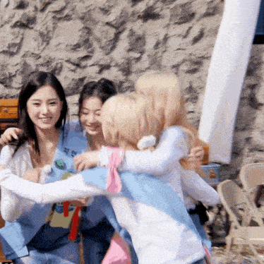 a group of girls are hugging each other with one wearing a shirt that says ' a ' on it