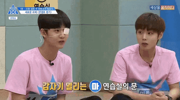 two young men wearing pink shirts are sitting next to each other and one has an eye patch on