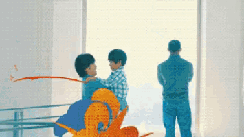 a man is standing in front of a window watching two children playing with paint