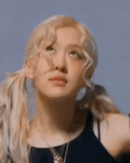 a close up of a woman 's face with blonde hair and pigtails looking up .
