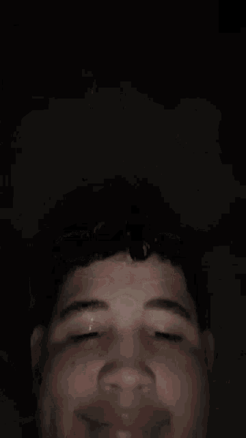 a young man is smiling and making a funny face .