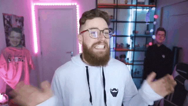 a man with a beard and glasses is wearing a white hoodie with a mustache on it