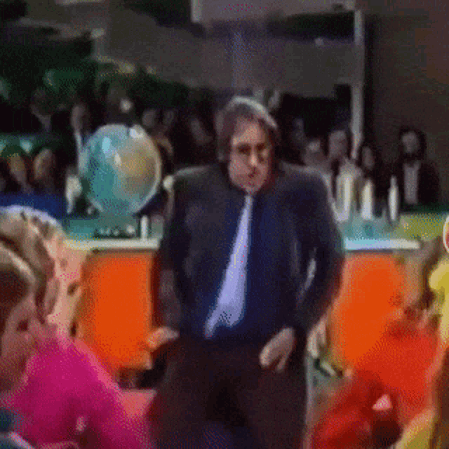 a man in a suit and tie is standing in front of a crowd of people