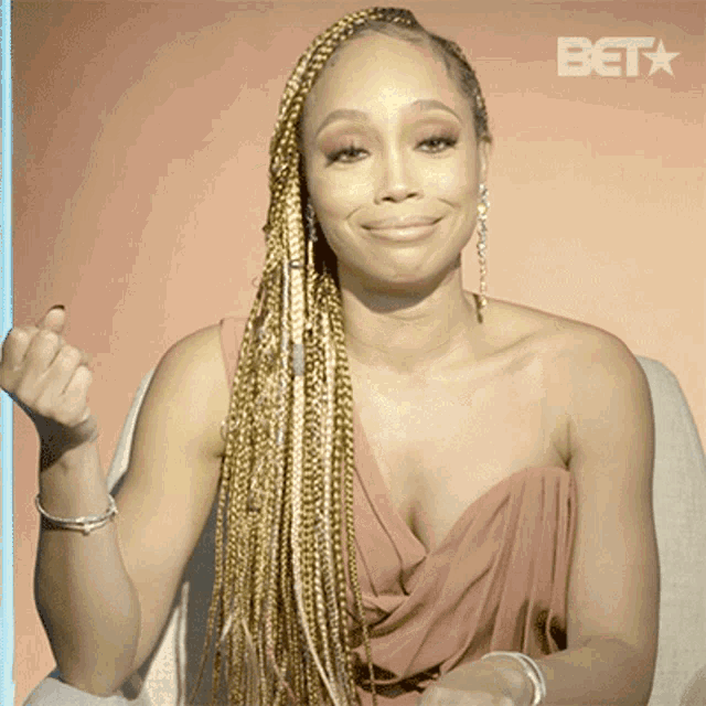 a woman sitting in a chair with a bet logo in the corner