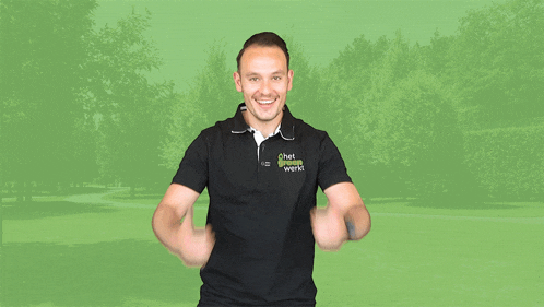 a man wearing a shirt that says ' het groene werk ' on it gives a thumbs up