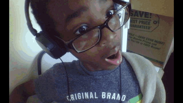 a young boy wearing glasses and headphones is wearing a shirt that says original brand