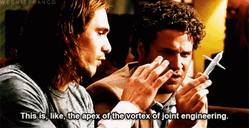 two men are looking at a model airplane and one of them is saying this is like the apex of the vortex of joint engineering