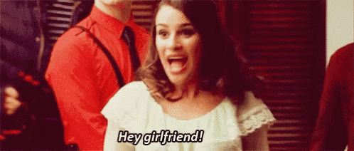 a woman is screaming and saying `` hey girlfriend '' while standing in front of a group of people .