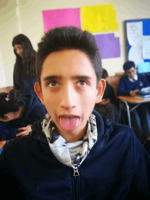 a boy sticking his tongue out in front of a classroom