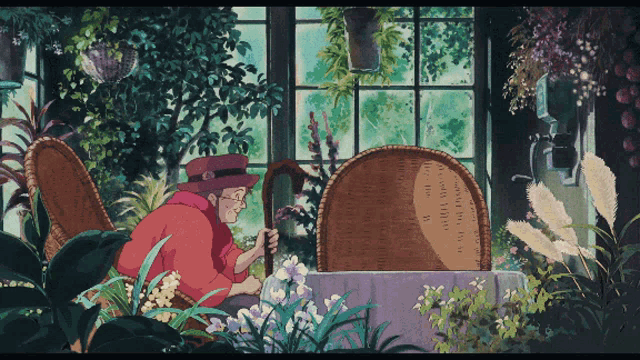 a woman with a cane sits in a chair in a greenhouse