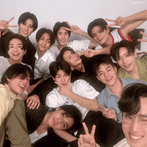 a group of young men are posing for a picture and one of them is wearing a white shirt