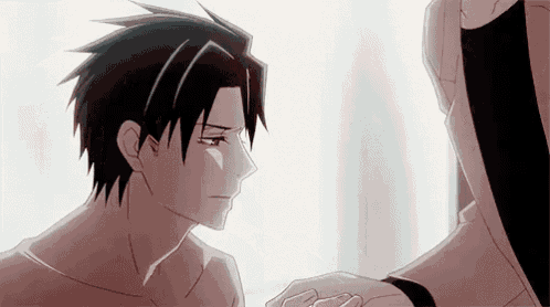 a man is holding another man 's hand while looking at him .
