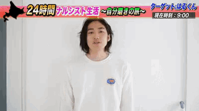 a man in a white shirt is standing in front of a sign that says 24 時間