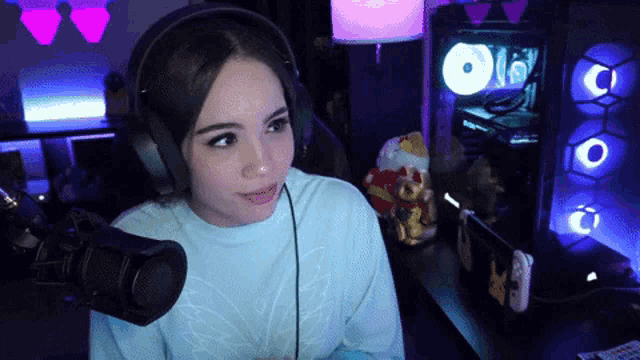 a woman wearing headphones is sitting in front of a microphone .