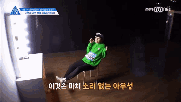 a person in a green shirt is sitting on a chair with their legs crossed and a move mnet logo in the background