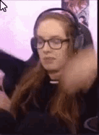 a woman wearing headphones and glasses is sitting in front of a computer monitor .
