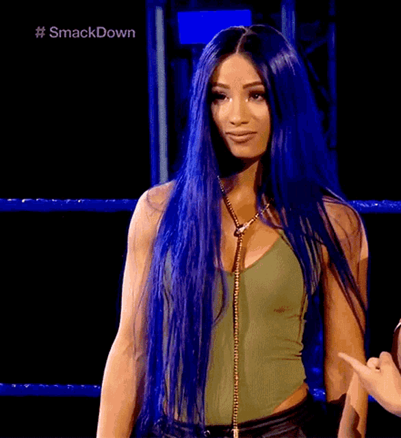 a woman with long blue hair is standing in a wrestling ring with the hashtag #smackdown