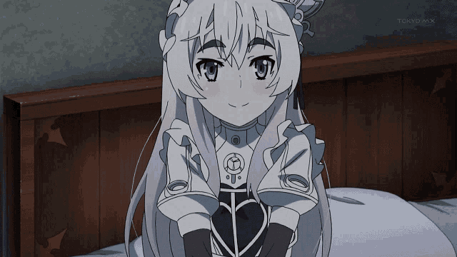 a girl is sitting on a bed in front of a tokyo mx logo
