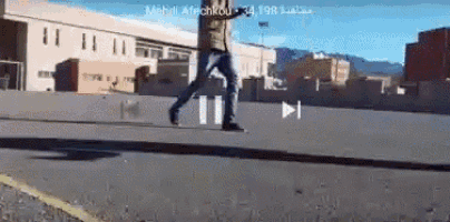 a man is walking down a street with a play button on the bottom
