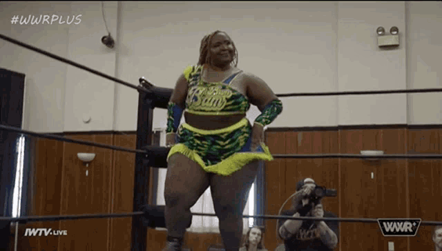 a woman is standing in a wrestling ring with the words wwrplus on the bottom of the screen