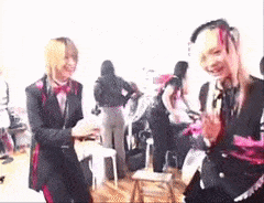 a group of people are standing in a room and laughing .