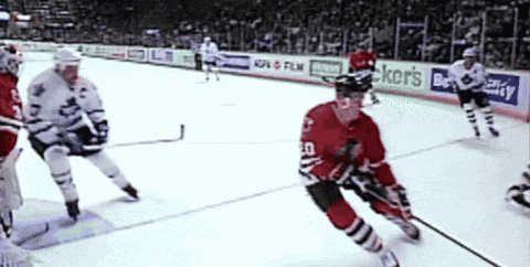 a hockey game is being played in front of an ad for baker 's beauty