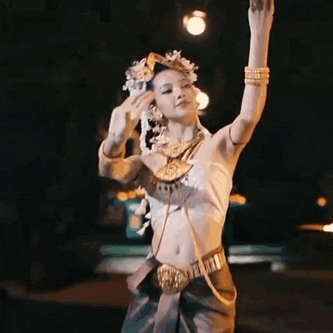 a woman in a traditional costume is dancing on a stage .