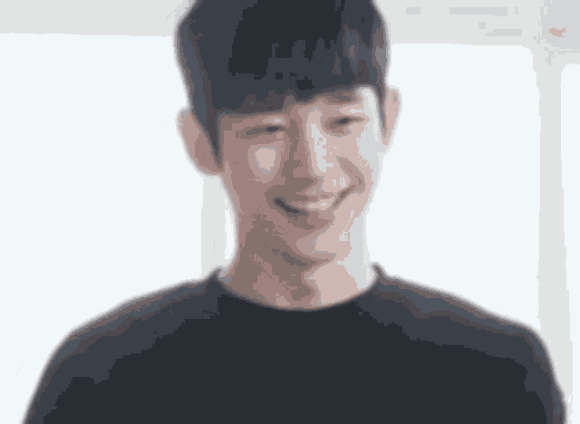 a young man in a black shirt is smiling .