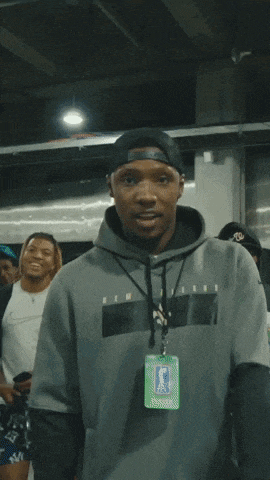 a man wearing a gray hoodie and a lanyard with a badge that says ' nba '