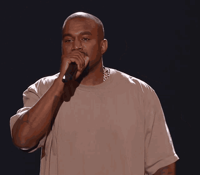 a man is singing into a microphone and pointing his finger