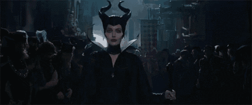 a woman with horns is standing in front of a crowd with the words well well behind her