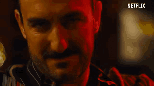 a close up of a man 's face with a netflix logo in the background