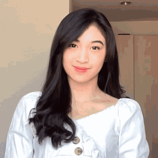 a woman wearing a white shirt with buttons on it